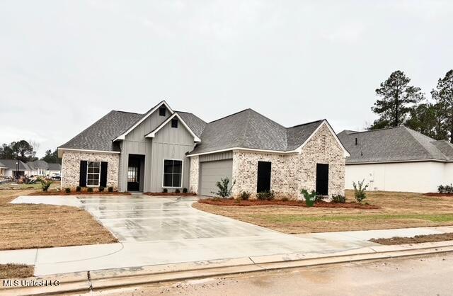 view of front of house with a garage, driveway, board and batten siding, and roof with shingles