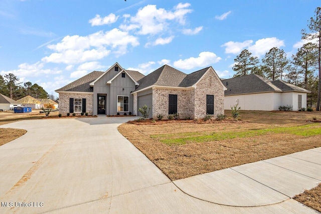 view of front of property featuring an attached garage, brick siding, a shingled roof, driveway, and board and batten siding