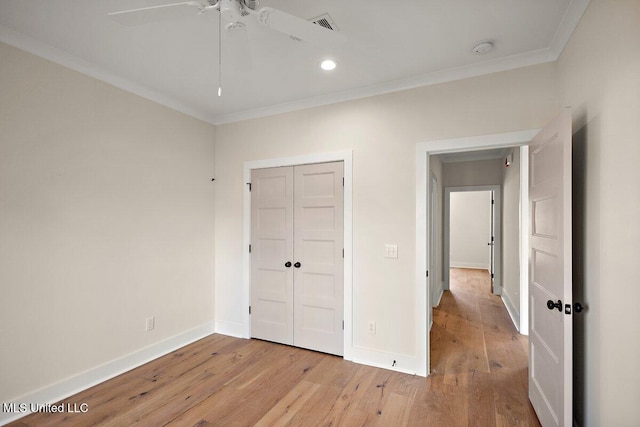 unfurnished bedroom with baseboards, light wood finished floors, and crown molding