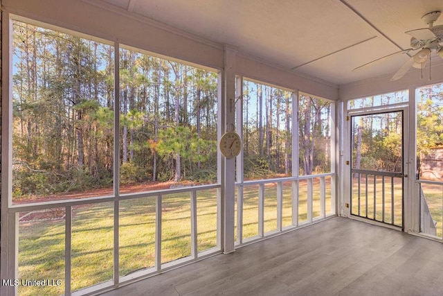 unfurnished sunroom with ceiling fan