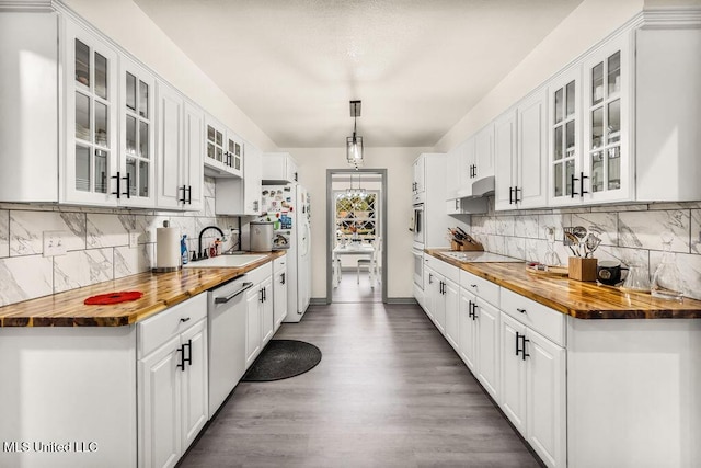 kitchen with wood counters, white appliances, backsplash, white cabinets, and hanging light fixtures