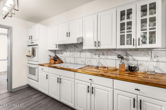 kitchen with electric stovetop, white cabinetry, dark hardwood / wood-style floors, and wood counters