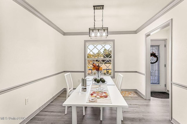 dining room with hardwood / wood-style flooring, a notable chandelier, and ornamental molding