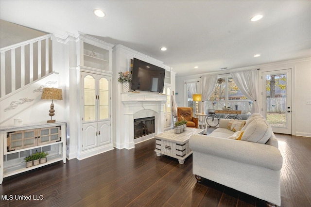 living room with crown molding and dark wood-type flooring