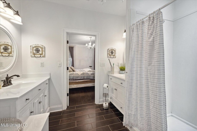 bathroom featuring a chandelier, vanity, wood-type flooring, and walk in shower