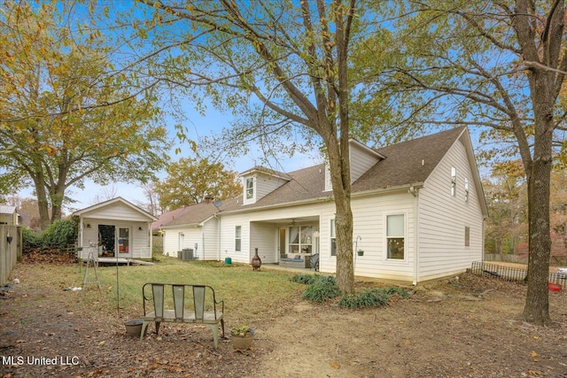 rear view of house featuring central air condition unit, a lawn, and covered porch