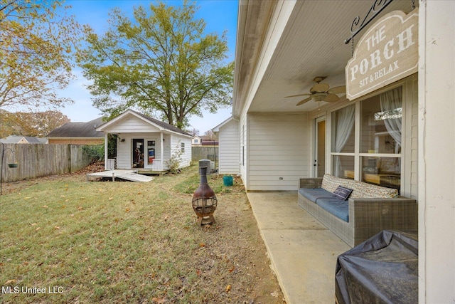 view of yard with an outdoor living space, ceiling fan, and an outdoor structure