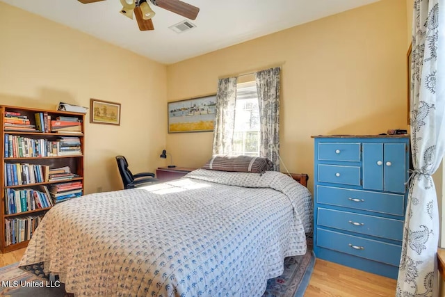 bedroom with a ceiling fan, visible vents, and light wood finished floors