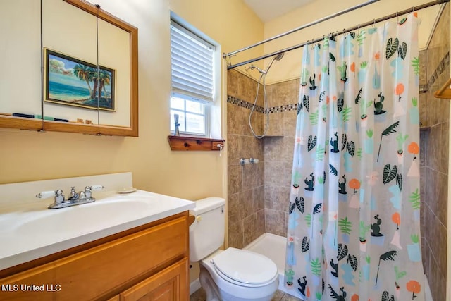 bathroom with toilet, vanity, and a tile shower