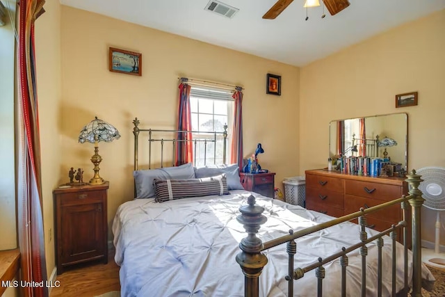 bedroom with visible vents, a ceiling fan, and wood finished floors