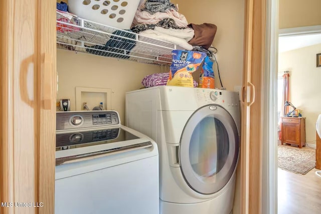 clothes washing area featuring laundry area and washer and clothes dryer