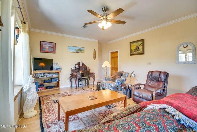 living room featuring visible vents, wood finished floors, ceiling fan, and crown molding