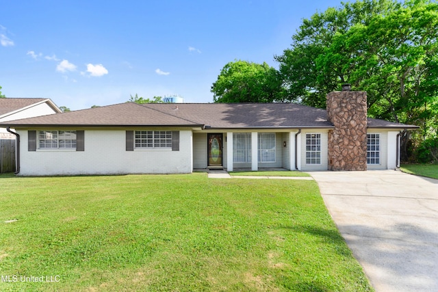 ranch-style home featuring a front lawn, a chimney, brick siding, a shingled roof, and driveway