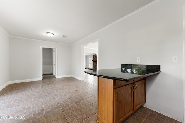 kitchen with dark countertops, baseboards, brick patterned floor, and arched walkways