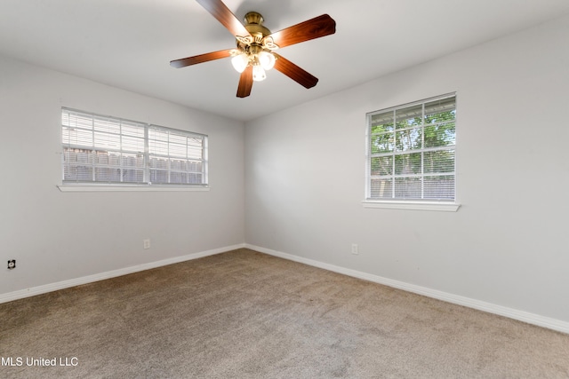 unfurnished room with plenty of natural light, carpet, ceiling fan, and baseboards