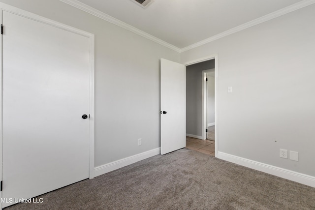 unfurnished bedroom with crown molding, carpet flooring, and baseboards
