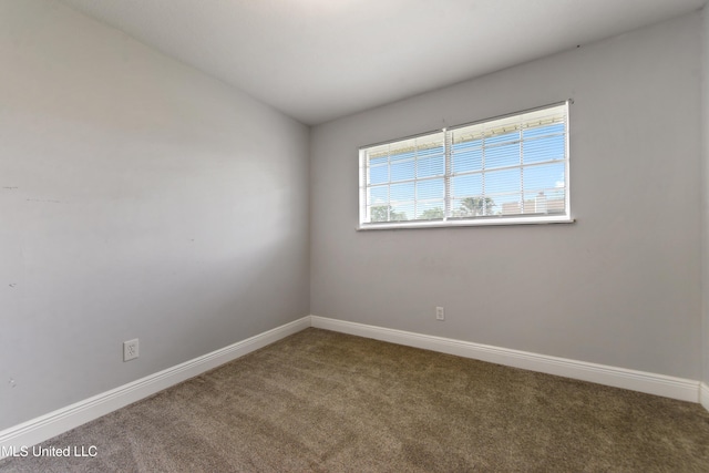 carpeted spare room featuring baseboards
