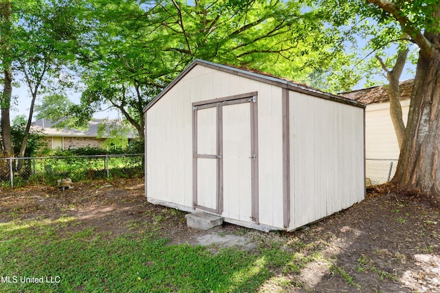 view of shed featuring fence