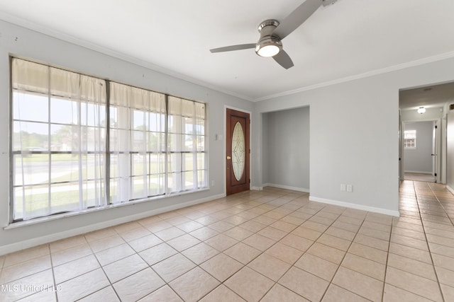 interior space featuring crown molding, a ceiling fan, baseboards, and light tile patterned floors