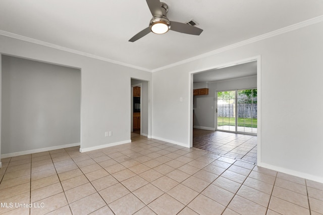 spare room with crown molding, visible vents, light tile patterned flooring, baseboards, and ceiling fan