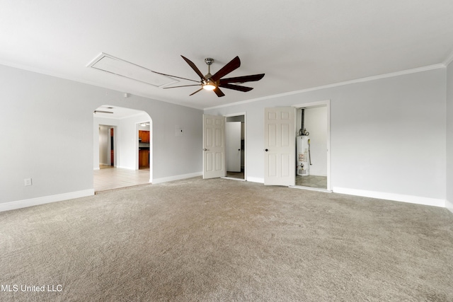 empty room featuring ceiling fan, attic access, light colored carpet, water heater, and ornamental molding