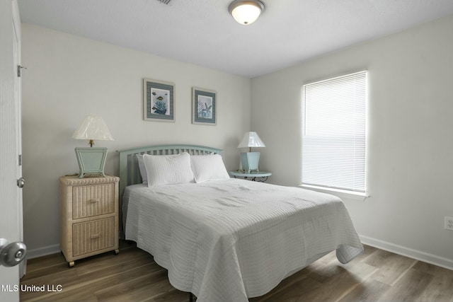 bedroom featuring baseboards and wood finished floors