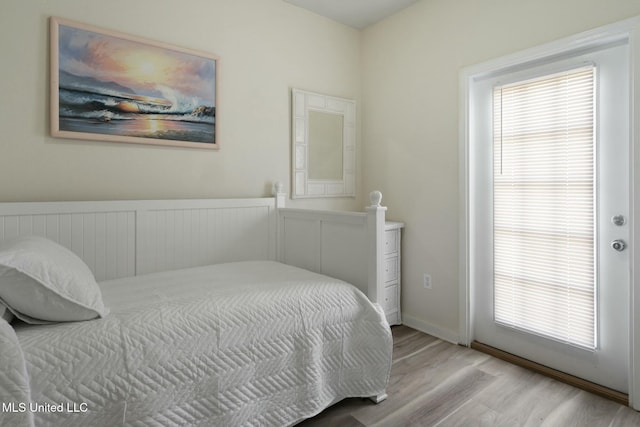 bedroom with multiple windows and wood finished floors