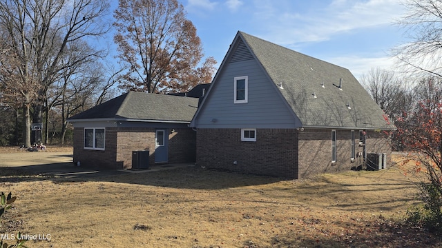 back of house with a yard and central air condition unit