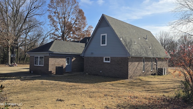 back of property with a yard and central AC unit