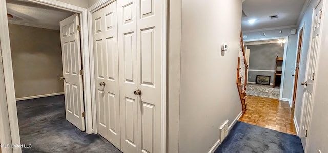 hall with dark parquet floors and crown molding