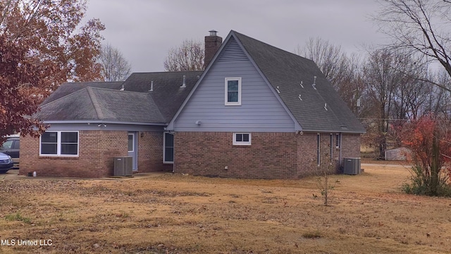 rear view of house featuring a yard and central AC