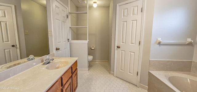 bathroom with tile patterned floors, vanity, toilet, and a bathing tub