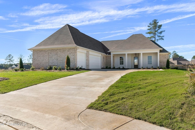 view of front of home featuring a garage, covered porch, and a front lawn