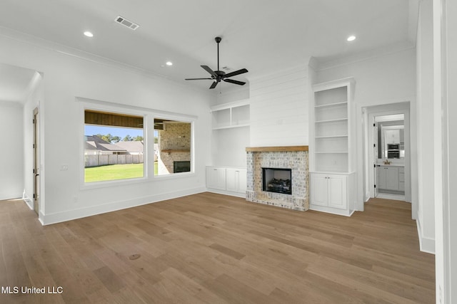 unfurnished living room with ceiling fan, light hardwood / wood-style floors, ornamental molding, and built in features