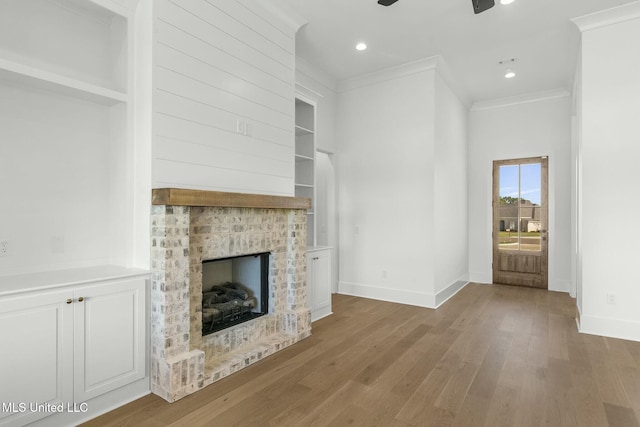 unfurnished living room with a fireplace, light wood-type flooring, and ornamental molding