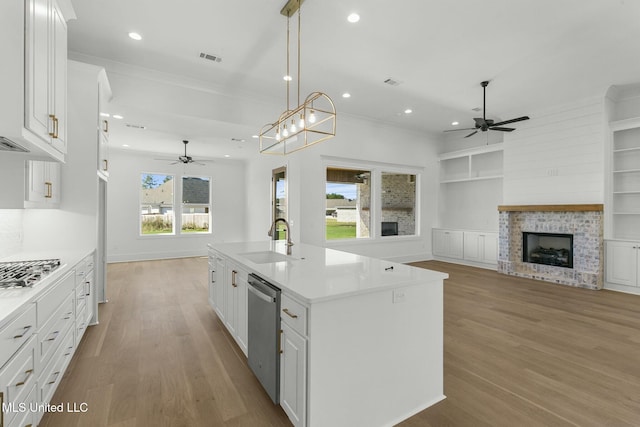 kitchen with white cabinetry, a wealth of natural light, and a kitchen island with sink