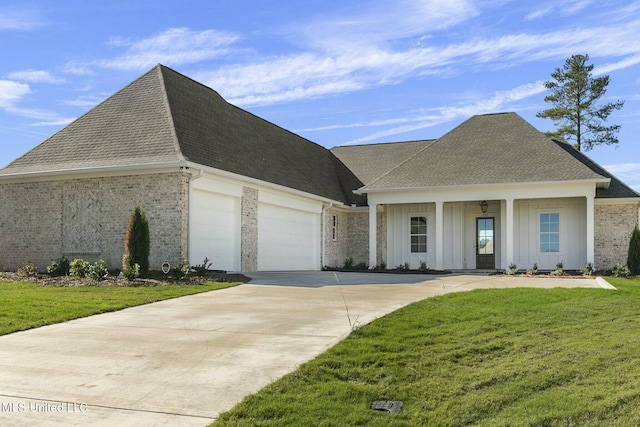 view of front facade featuring a front lawn, covered porch, and a garage