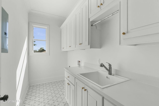 clothes washing area with sink, cabinets, electric panel, hookup for a washing machine, and ornamental molding