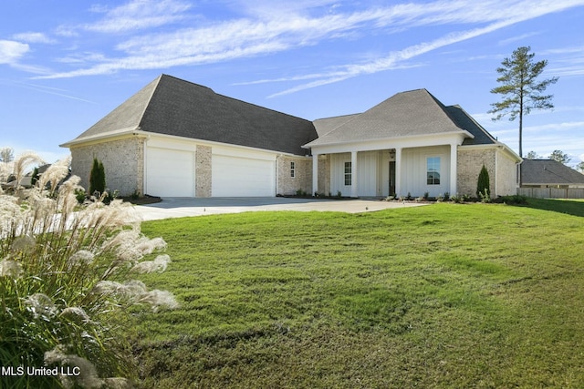 view of front of property featuring covered porch, a garage, and a front lawn