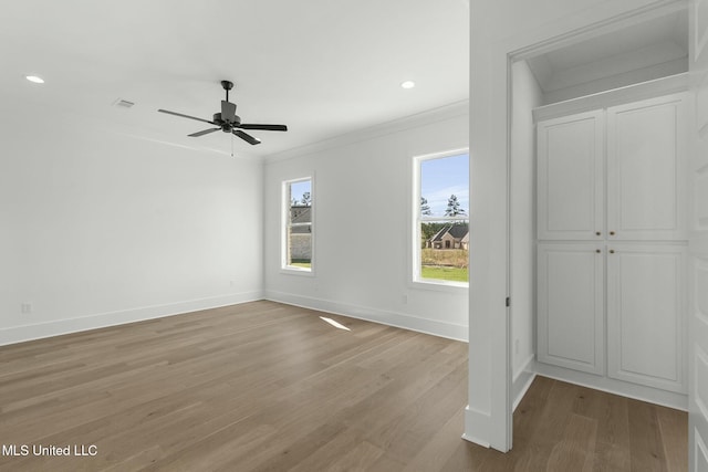 interior space with a closet, light hardwood / wood-style flooring, ceiling fan, and crown molding