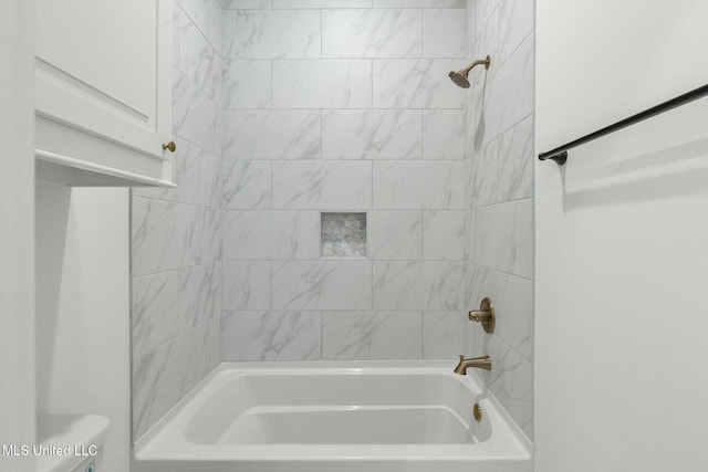 bathroom featuring tiled shower / bath combo and toilet