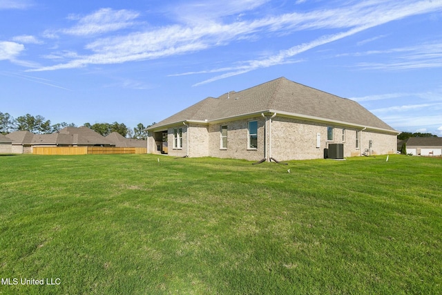 view of side of property featuring central air condition unit and a yard