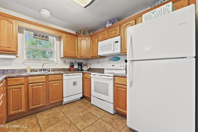 11334 Texas St, Bay Saint Louis, MS 39520 - kitchen with white appliances, a sink, light tile patterned floors, dark countertops, and brown cabinets