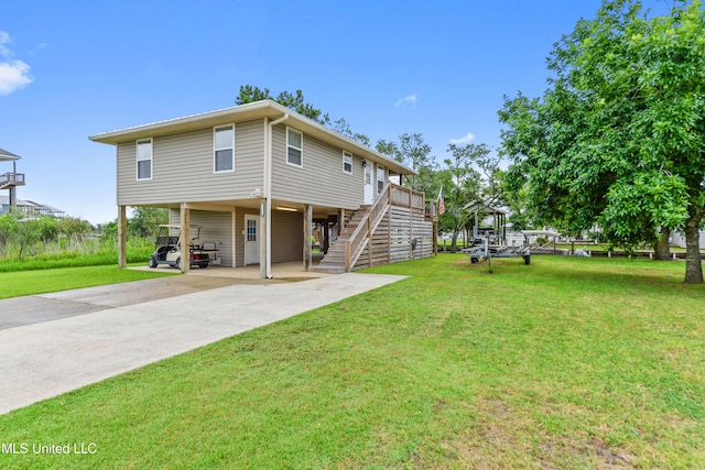 11334 Texas St, Bay Saint Louis, MS 39520 - rear view of property featuring a carport, concrete driveway, stairway, and a lawn