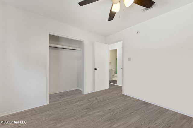 unfurnished bedroom featuring visible vents, wood finished floors, a closet, baseboards, and ceiling fan