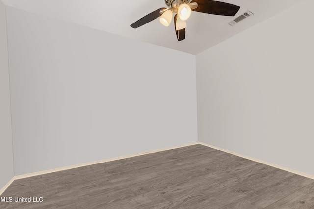 unfurnished room featuring ceiling fan, visible vents, baseboards, and wood finished floors