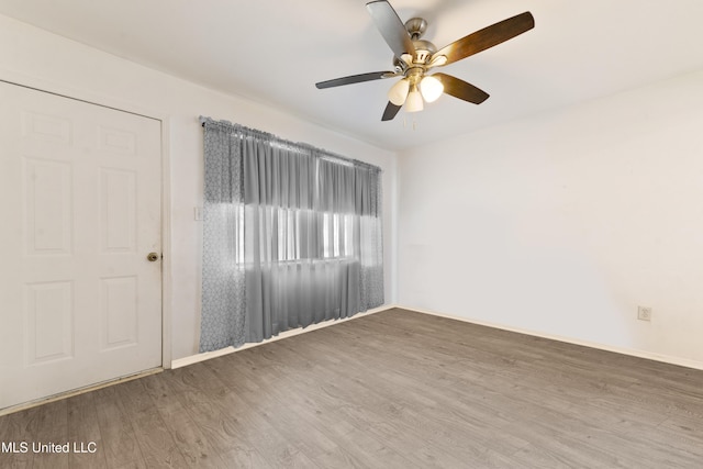 unfurnished room featuring ceiling fan, baseboards, and wood finished floors