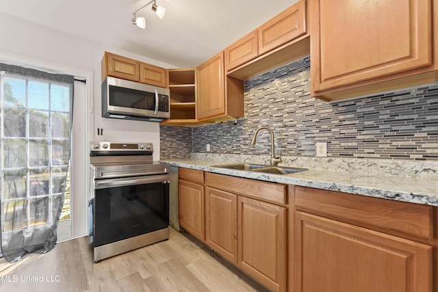 kitchen featuring light wood finished floors, a sink, decorative backsplash, stainless steel appliances, and open shelves
