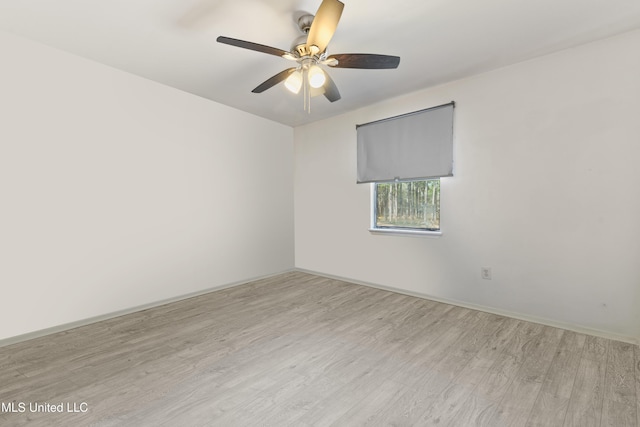 unfurnished room with ceiling fan, baseboards, and light wood-style flooring