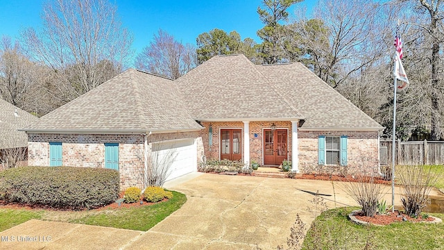 view of front of house featuring fence, a shingled roof, concrete driveway, a garage, and brick siding